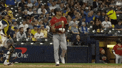 Sports gif. Christian Walker of the Arizona Diamondbacks throws his bat and jogs to first base in a casual way like he just hit it out of the park.