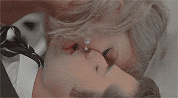 Music video gif. Taylor swift in the Blank Space music video is on top of a man in a suit and tie. His eyes are closed as she bites his lips sensually. 