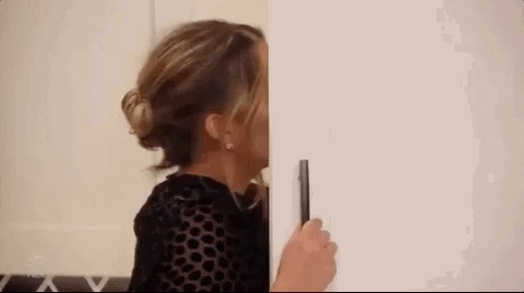 Celebrity gif. Chrissy Teigen holds open a kitchen cabinet to grab something out of it. She slowly turns around, peering out of the corner of her eye, and looks extremely annoyed. 