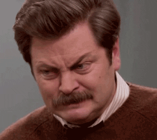 Parks and Recreation gif. Nick Offerman as Ron stares angrily at something, his mustache upside-down and his brow furrowed. This man is maaaad.
