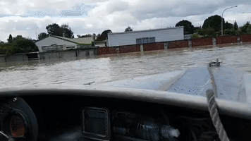 Motorboat Speeds Past Flood-Hit Houses in Edgecumbe, New Zealand