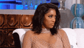 Reality TV gif. Porsha Williams is taken aback and her eyes widen while she rolls her head to the side before abruptly stopping.