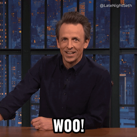 Late Night gif. Seth Meyers winds up and puffs out an excited "WOO!"