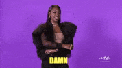 Celebrity gif. Wearing a black jacket with ruffled sleeves, Justine Skye swings her arms and leans back while smiling; text, "Damn."