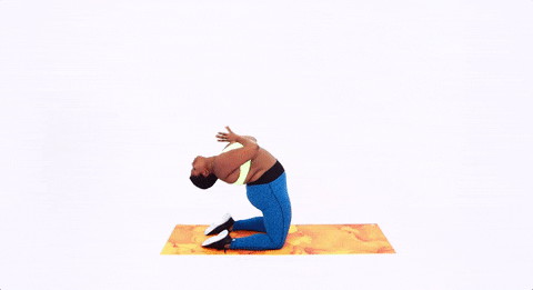 Video gif. Stretching on an orange yoga mat, influencer Jessamyn Stanley balances on her knees, bending backward and reaching behind herself.