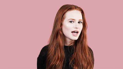 Celebrity gif. Madelaine Petsch winks at us emphatically with her head turned to the side.