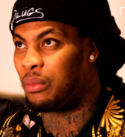 Celebrity gif. Waka Flocka Flame rolls his eyes, making a subtly disgusted facial expression during an interview on The People Vs.
