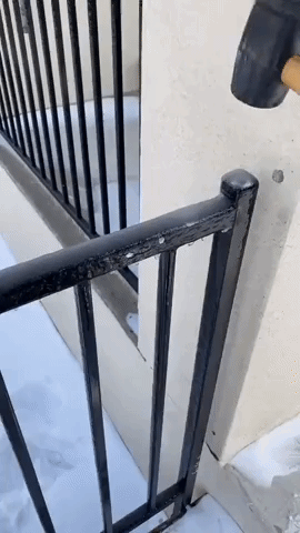 Austin Resident Uses Hammer to Knock Ice Off Railing During Winter Storm