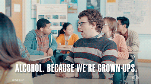 TV gif. Jacob Houston as Victor sits in a classroom at his desk chair, talking to someone seriously, adjusting his glasses as he says, "Alcohol. Because we're grownups."