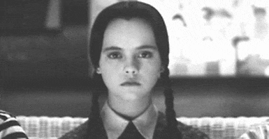 Movie gif. A very serious Christina Ricci as Wednesday in The Addams Family holds her head up and takes a deep breath.