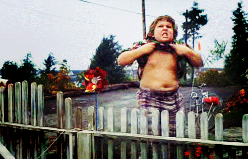 Movie gif. Jeff Cohen as Chunk on the Goonies raising his shirt, sneering and shaking his belly, aka doing the truffle shuffle.