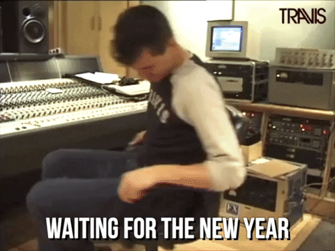 Celebrity gif. Neil from the band Travis spins in an office chair in a recording studio. Text, "waiting for the new year." Event Trends.