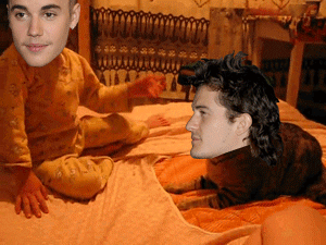 Celebrity gif. Faces of Justin Bieber and Orlando Bloom are pasted onto the heads of a child and a cat. The child violently slaps the cat and in response, the cat lurches at them and pushes them off of the bed.