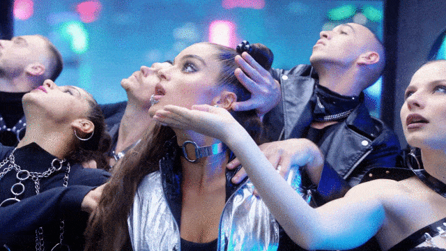 Music video gif. From the video for Thought About That, Noa Kirel in the center of five dancers with their hands on her and moving as if they are one body, swaying their heads left and right and then jerking towards the center.