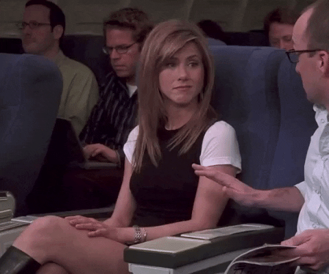 Friends gif. Jennifer Aniston as Rachel Green sits on a plane having a conversation with the man sitting next to her. She shrugs, lifting her hands in the air, as she turns to him and says, "Well," trailing off. Text, "Well..."