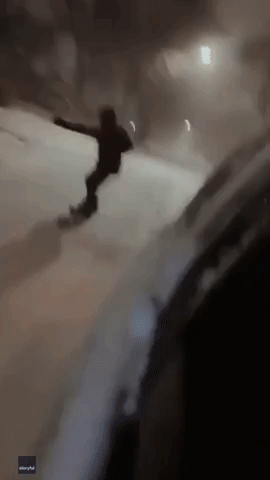 Snowboarder Towed Behind Car Through Snowy Chicago Streets