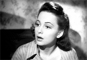 Celebrity gif. Black and white footage of Olivia de Haviland as she tilts her head in confusion, blinking as if to say, “Are you kidding me?”