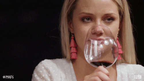 Reality TV gif. A woman on Married at First Sight lifts her wine glass high to take a sip. She rolls her eyes and shakes her head, super annoyed. 