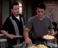 Friends gif. Matthew Perry as Chandler side-eyes Matt LeBlanc as Joey as he piles scrambled eggs onto his plate. When Joey notices him, he begrudgingly puts a spoonful on Chandler's plate.