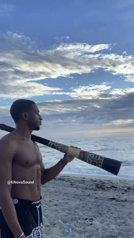 Playing The Didgeridoo At Sunrise On The Beach