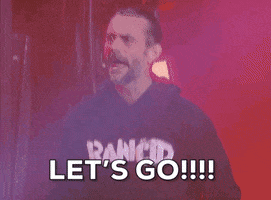 Sports gif. CM Punk on AEW Rampage screams "Let's Go!!!" while lights flash and smoke rises behind him.