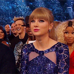 Celebrity gif. In the audience at an awards show, a dolled-up Taylor Swift nods and shrugs her shoulders in agreement.