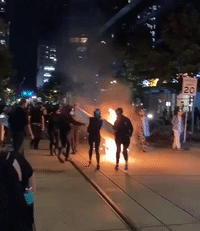 Portland Demonstrators Drag Burning Mattress Through Street as Police Declare Protest a Riot