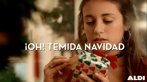 Ad gif. Teen girl looks at the tag of a small Christmas gif and snarls, disappointed, and puts it down. Text, "Oh! Temida navidad."
