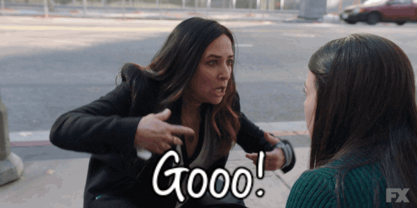 TV gif. Pamela Adlon as Sam in Better Things kneels in front of a woman and looks frantic as she says, "GO!" while pointing down the street and pushing the woman to rise and run.