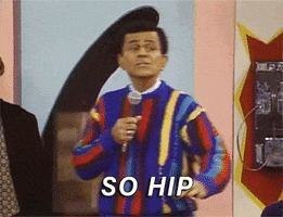 TV gif. Casey Kasem on Saved By the Bell, wearing a primary-color '80s sweater, steps back and raises an "ok" hand symbol while speaking into a microphone, "so hip," which appears as text.