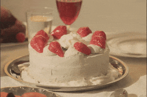 Video gif. The words "happy anniversary" appear over a white-frosted cake decorated with strawberries, which suddenly gets stepped on by a person wearing clear pleaser heels.