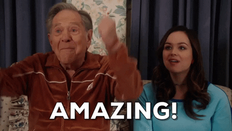TV gif. George Segal as Pops in The Goldbergs drops his fists in declarative excitement, saying "Amazing," Hayley Orrantia as Erica smiling beside him.