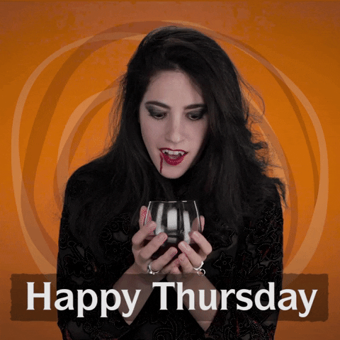 Video gif. A woman wearing all black with vampire's teeth holds a glass full of blood. She excitedly takes a drink, blood dripping down the corner of her mouth. Text, “Happy Thursday.”