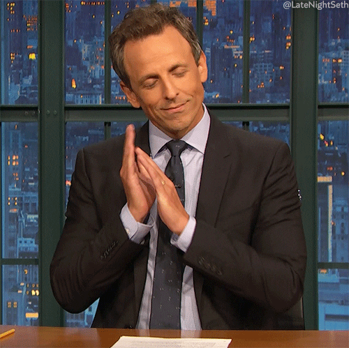 Late Night gif. Seth Meyers puts his hands to his face and snuggles into them, closing his eyes and feigning sleep.