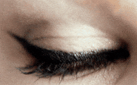 Video gif. An extreme close-up shot of a woman's eye shows the eye blinking repeatedly.