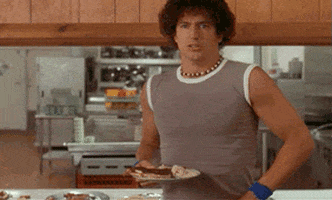 Movie gif. Ken Marino, as Victor in Wet Hot American Summer awkwardly drops a plate of food and then tries to pretend like it didn’t happen by posing nonchalantly.
