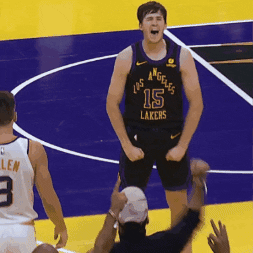 Sports gif. Camera zoom on Austin Reaves of the Los Angeles Lakers during a game, flexing his biceps and screaming with eyes squeezed shut. 