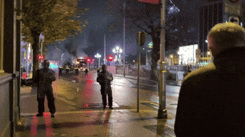 Police Stand in Front of Blazing Bus Amid Dublin Protests