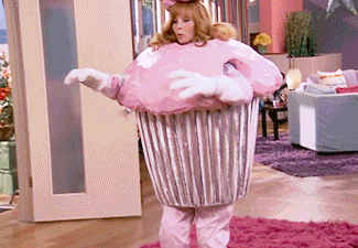 TV gif. Lisa Kudrow as Valerie in The Comeback. She's dressed in a super pink cupcake costume completely with a cherry on top of her head and she falls over, landing on her back. She lays on the floor, assessing the situation.