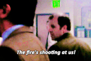 The Office gif. Ed Helms as Andy panics and yells at his coworkers, "the fire's shooting at us!" which appears as text.