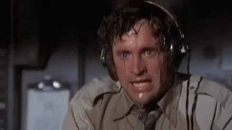 Movie gif. Robert Hays as Ted from Airplane! sweats vigorously, the perspiration dripping down his face and soaking his clothes. He wipes his hand over his brow, to no avail.