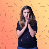 Video gif. Erica Seamster looks at us with a serious expression on her face, rubbing her hands together like she has an evil plan. Text appears behind her against a yellow-orange background, "Mwahahahahaha."