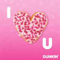 Sponsored gif. Pink heart-shaped donut covered in sprinkles pulses like a real heart. The letter I is to the left of the donut and the letter U is to its right, making the message, “I love you.”