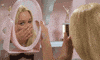 Movie gif. Christine Taylor as Marcia in "The Brady Bunch" holds up a pink plastic framed mirror and admires herself, patting her face and tousling her hair and blowing a kiss.