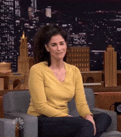 The Tonight show gif. Sarah Silverman laughs and covers her face with her hand, and then looks over at Jimmy with a smile.