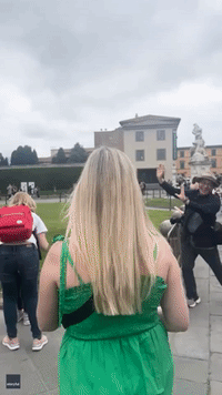Mischievous Duo High-Fives Tourists Posing at Leaning Tower of Pisa