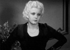 Movie gif. Actress Jean Harlow as Ann Schuyler in Platinum Blonde bursts into a giggle and covers her face.