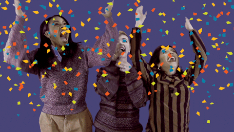 Video gif. Three women throw their arms up, cheering and celebrating as virtual confetti flies in the air.