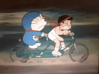 Anime gif. Doraemon frowns on the back seat of a tandem bicycle as the boy in front leans forward, clenching his teeth as he pedals rapidly.