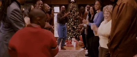 Movie gif. In This Christmas, partygoers in a Soul Train line clap rhythmically while a man begins to dance down between the two rows of people.